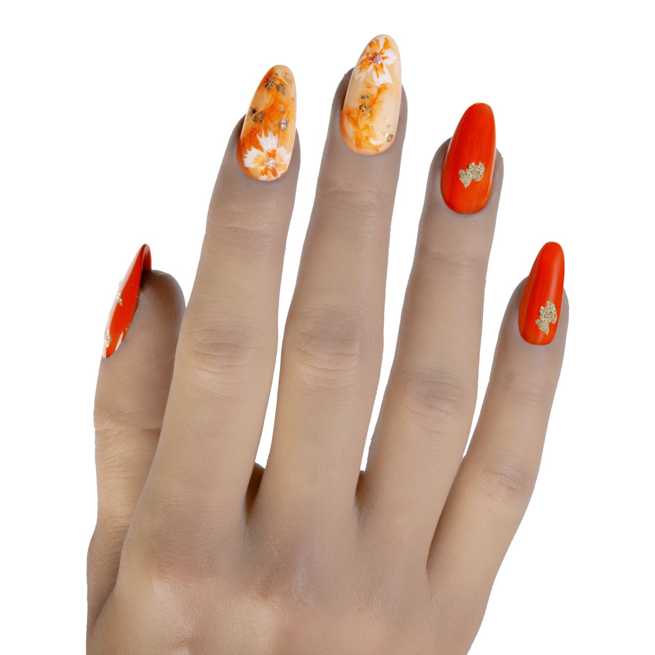 Press on nails arancioni con decorazioni floreali bianche e dettagli in foglia d’oro
