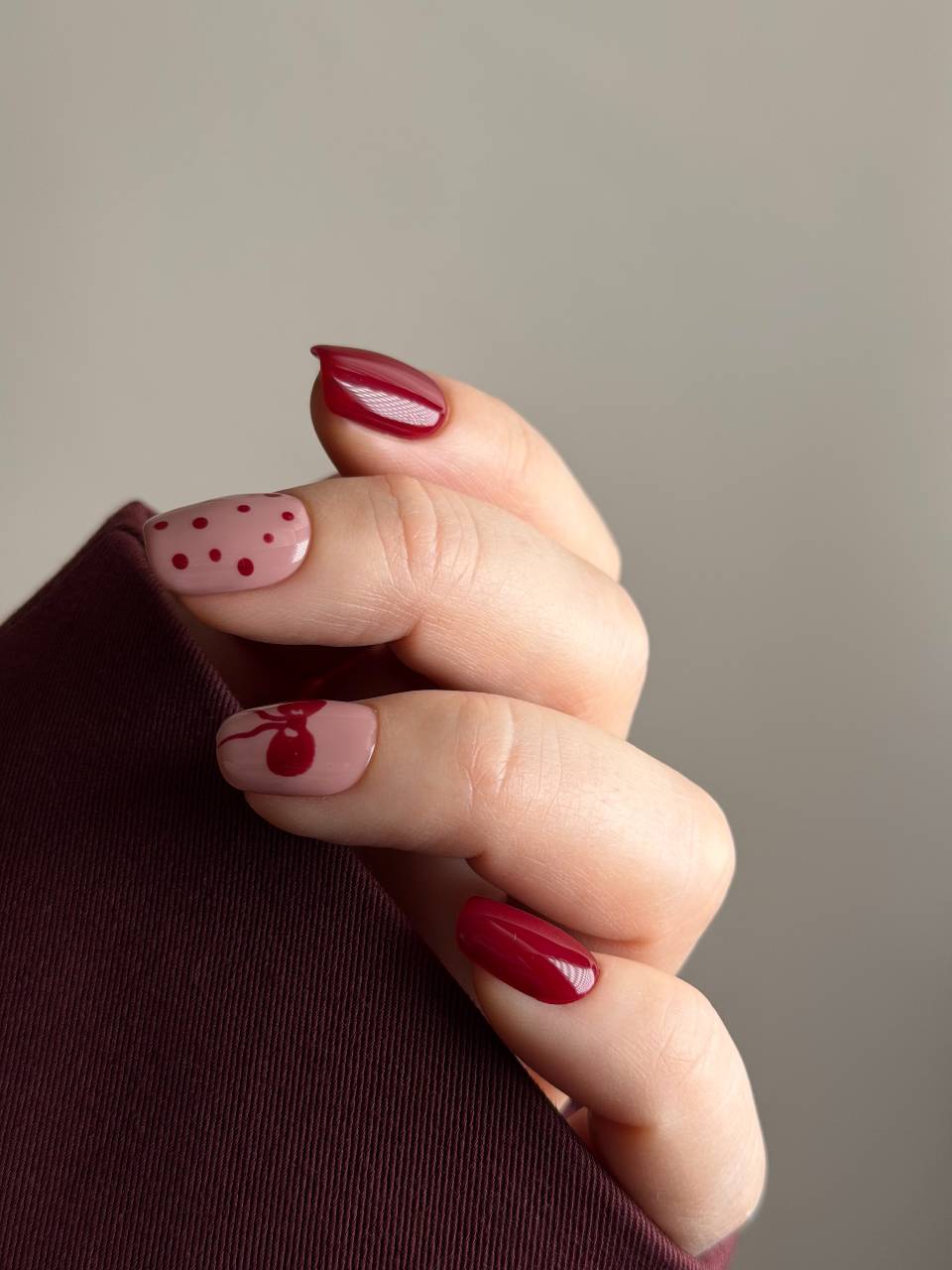 Press on nails bordeaux e rosa nude con pois rossi e decorazione a pallina di Natale