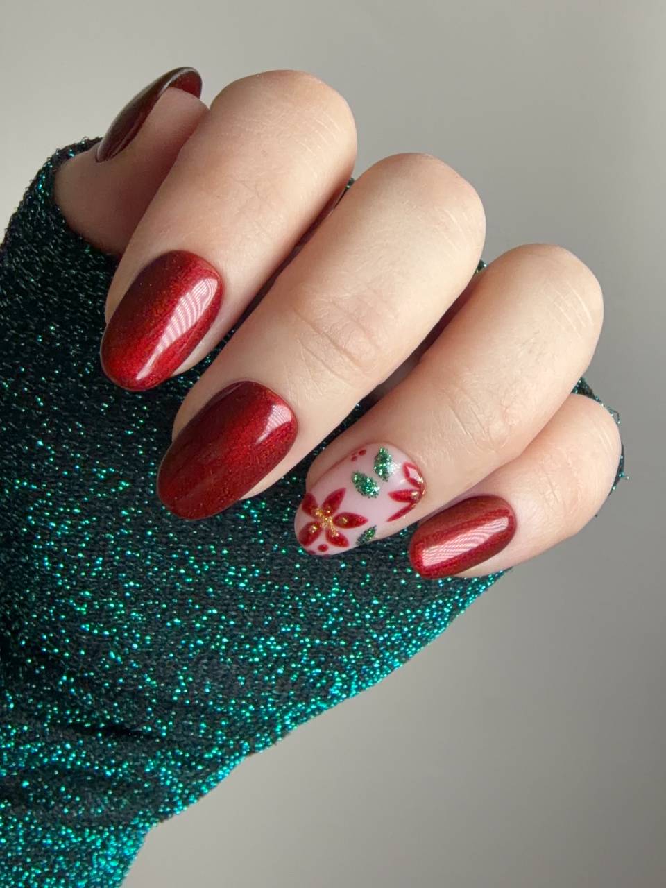 Press on nails rosse con decorazione natalizia a stella di Natale e dettagli glitter verdi